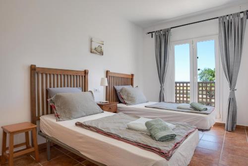 a bedroom with two beds and a balcony at Michalete Fernando - Sólo Familias in Conil de la Frontera