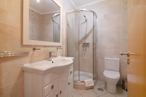 a bathroom with a shower and a sink and a toilet at Quarteira Beach I in Quarteira