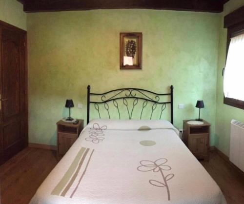 a bedroom with a bed and two night stands with lamps at Los Avellanos Casa 3 in Celis