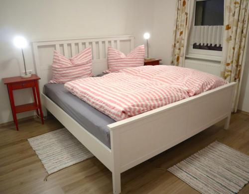 a bedroom with a white bed with pink pillows at Ferienwohnung im Haus Schwedes in Titisee-Neustadt