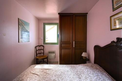 a bedroom with a bed and a window and a chair at Les Cigales in Cassis