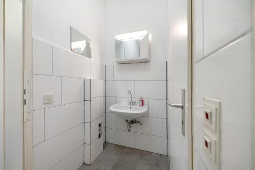 a white bathroom with a sink and a mirror at an der Mosel in Kaisersesch