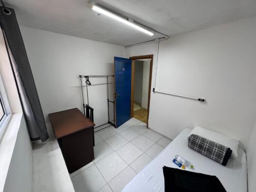 a room with a bed and a blue door at Pousada Solar de Mayo in Curitiba