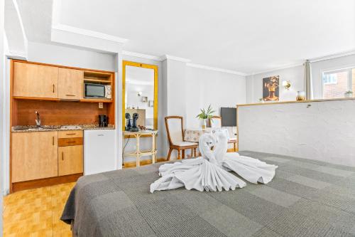 a bedroom with a bed with a white dress on it at Unique Apartahotel 3-2 in Torrevieja