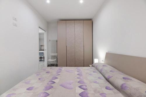 a bedroom with a large bed with purple flowers on it at La Casa Di Angio - Val D'Intelvi in Lanzo dʼIntelvi