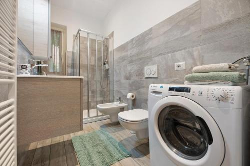 a bathroom with a washing machine and a toilet at La Casa Di Angio - Val D'Intelvi in Lanzo dʼIntelvi