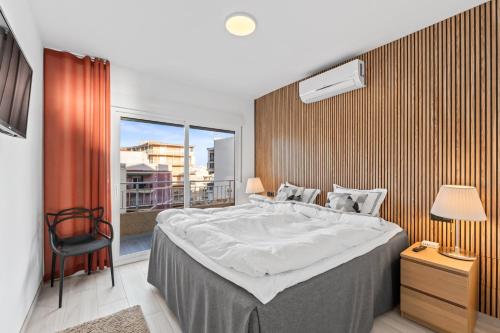 a bedroom with a large bed and a balcony at 100 Beach Seaview in Torrevieja