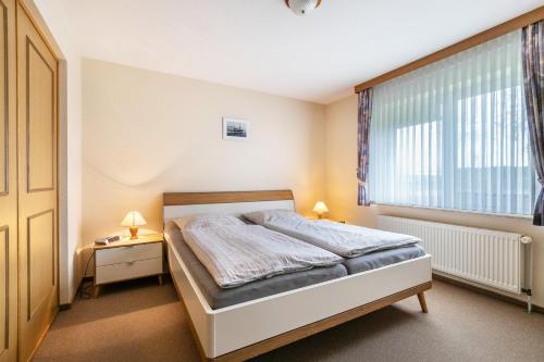 a bedroom with a bed and a window at Ferienhof Martens in Schülperweide