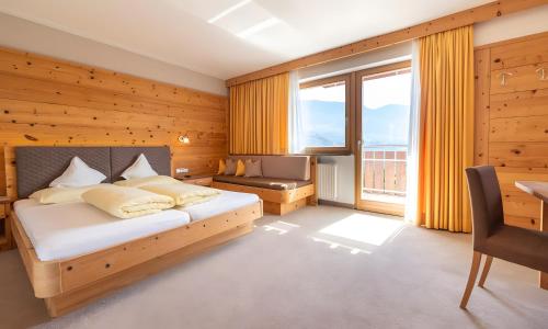 ein Schlafzimmer mit einem Bett und einem großen Fenster in der Unterkunft Passerblick in Dorf Tirol