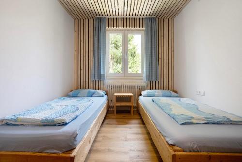 two beds in a room with a window at Kraichgauer Haus in Oberreute