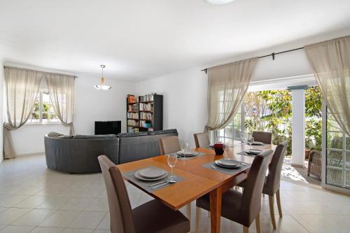 a dining room and living room with a table and chairs at Villa Galé in Guia