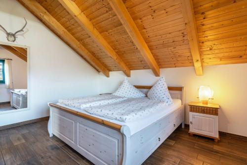 a bed in a room with a wooden ceiling at Blockhaus - Ferienwohnung Sunrise in Erdmannsdorf