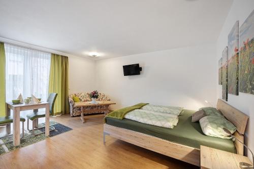 a bedroom with a bed and a living room at Ferienwohnung am Wiesenweg in Mauerstetten