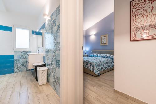 a small bedroom with a bed and a bathroom at Ibiscus Rosa 1 in Marongiu