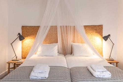 a bedroom with two beds with white sheets and two lamps at Casa das Alfazemas in Cadaval
