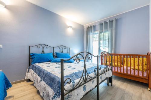a bedroom with a bed with blue pillows and a window at Ibiscus Rosa 1 in Marongiu