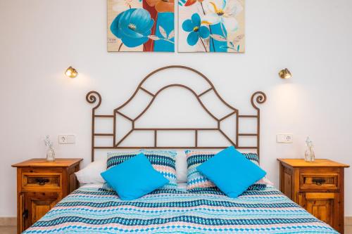 a bedroom with a large bed with blue pillows at Sa Mina in Santa Margalida