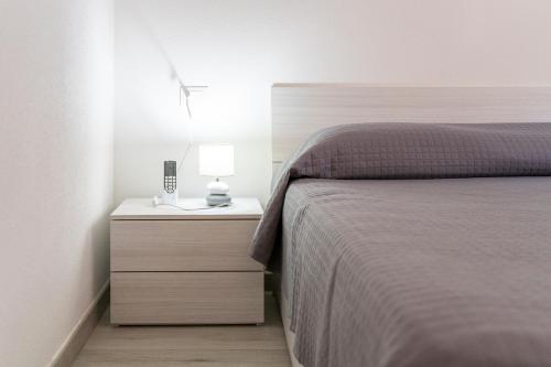 a bedroom with a bed and a lamp on a night stand at Casa Macis vista mare in Isola Rossa