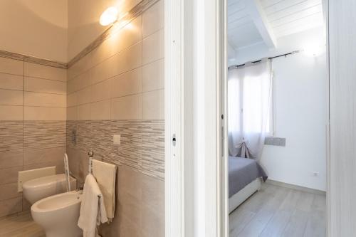 a bathroom with a toilet and a sink and a bed at Casa Macis vista mare in Isola Rossa