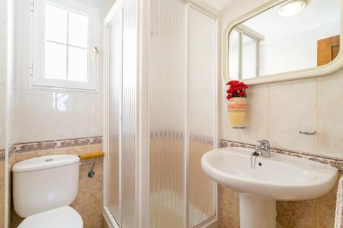a bathroom with a toilet and a sink and a mirror at Casa Susan in Torrevieja