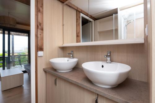 two sinks on a counter in a bathroom at Chalet 35m2 - Armen in Plouhinec