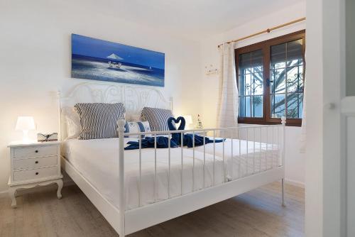 a white bedroom with a white bed and a window at Puerto Chico A in Playa Blanca