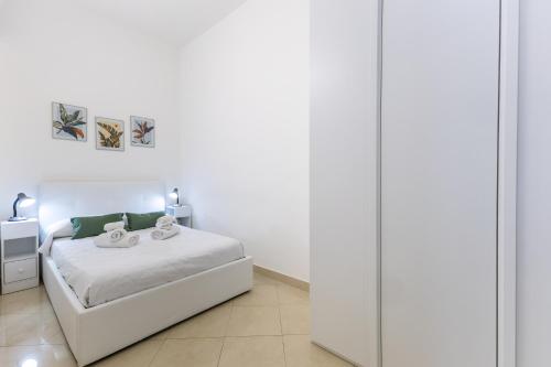 a white bedroom with a bed and a mirror at Dimora Biscari in Acate