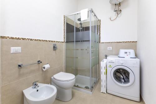a bathroom with a toilet sink and a washing machine at Dimora Biscari in Acate