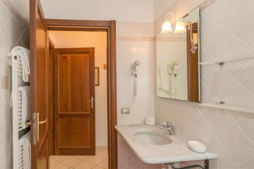 a bathroom with a sink and a mirror and a phone at Il Girasole - Malva in Venturina Terme