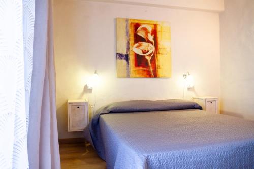 a bedroom with a bed and a painting on the wall at Appartamento il corso in Roccastrada