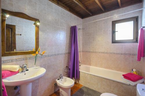 a bathroom with a sink and a toilet and a tub at Finca La Rubina in Teguise