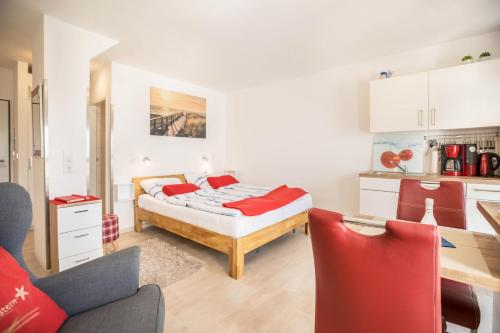 a bedroom with a bed and a kitchen at Ferienwohnung Seestern in Norderney