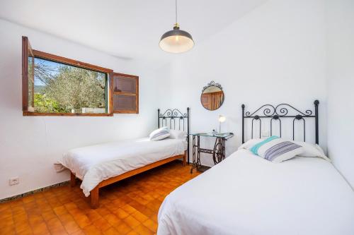 a bedroom with two beds and a window at Villa Can Tonet in Port de Pollensa