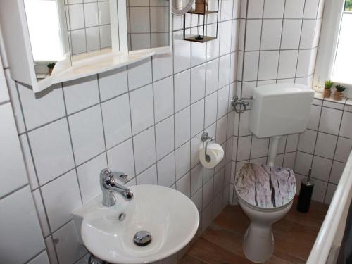 a white bathroom with a toilet and a sink at Ferienwohnung Niggemann in Bestwig