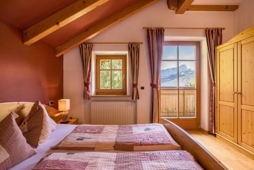 a bedroom with a large bed and a window at Oberplunerhof - Fewo Gitschberg in Chienes