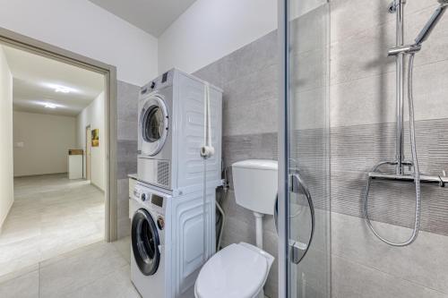 a bathroom with a washing machine and a toilet at Messapica Rooms in Ugento