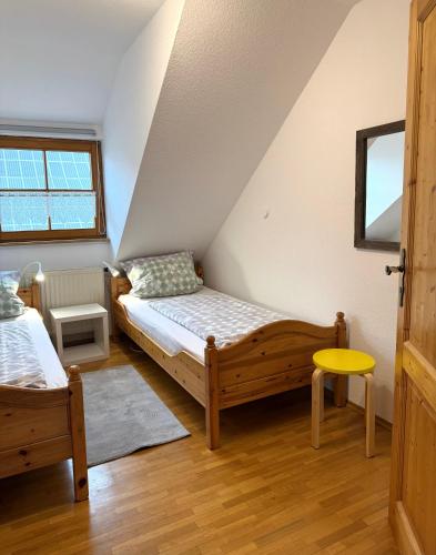 a small bedroom with a bed and a chair at Ferienhof Hanssler in Wilhelmsdorf