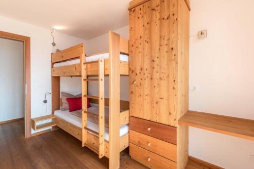 a bunk bed in a room with a wooden wall at Thalerhof App Melisse in Feldthurns