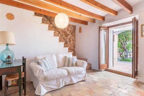 a living room with a white couch and a staircase at Little Paradise in Banyalbufar in Banyalbufar