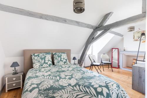 a bedroom with a bed with a green and white comforter at Gîte À L'aube - 3 chambres in Saint-Aignan