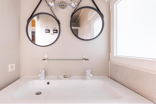 a bathroom with a white tub and a round mirror at Gîte À L'aube - 3 chambres in Saint-Aignan