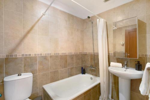 a bathroom with a toilet and a sink and a tub at Ático Garajonay in Cabo Blanco