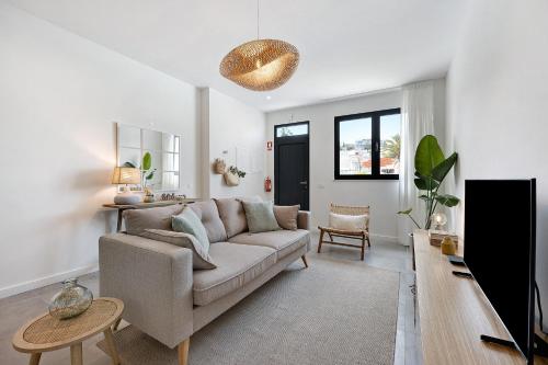 a living room with a couch and a tv at Casa Helena in Ferragudo