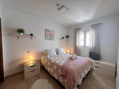 a bedroom with a bed and two lamps and a window at Ático Garajonay in Cabo Blanco