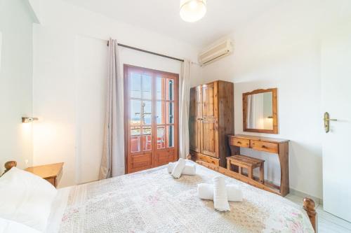 a bedroom with a large bed and a mirror at Arianna apartment 10 in Paleokastritsa
