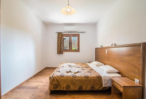 a bedroom with a large bed with a wooden headboard at Mirage Arillas Villa Apartment in Arillas