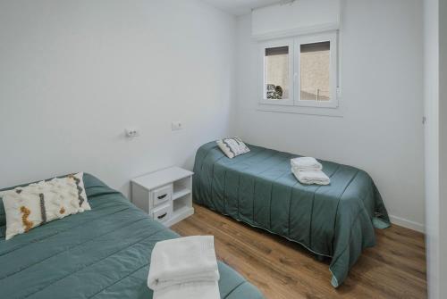 a bedroom with two beds and a window at Casa La Isi in Rades de Abajo