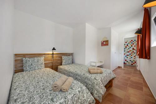 a bedroom with two beds with towels on them at Apartment Amado - Carrapateira in Carrapateira