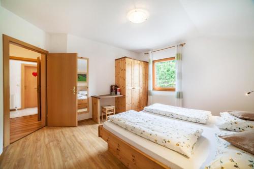 a bedroom with two beds and a desk at Langeshof Fewo Löwenzahn in Caines
