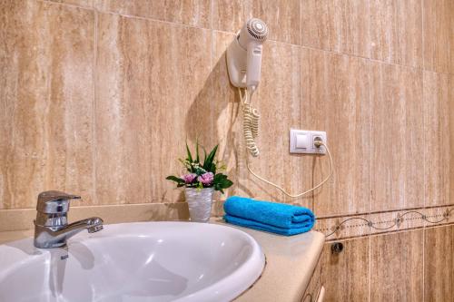a bathroom sink with a blow dryer on a wall at Apartament Yaco 2 in Lloret de Mar